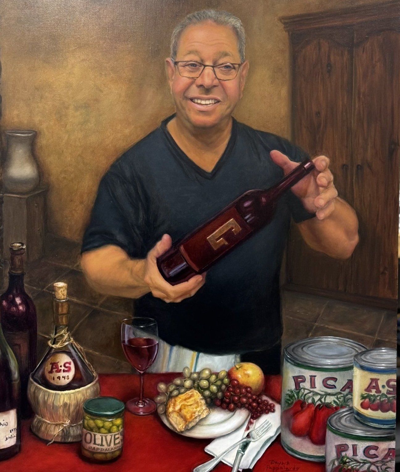 Smiling man holding a wine bottle at a table of Italian still life
